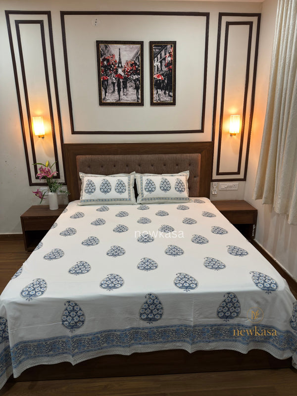 Rajasthan blue paisley hand block printed cotton bedsheet king size styled on bed with wooden stand and wall décor
