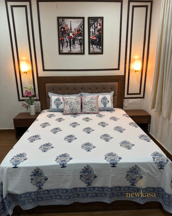 newkasa artisan-crafted blue floral vase motif hand block cotton bedsheet king size, bedroom setup with lamp and Lily flower adding heritage comfort. with cushion cover and rajasthani and jaipur print