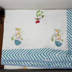 Baby blanket with cartoon designs on a wooden surface