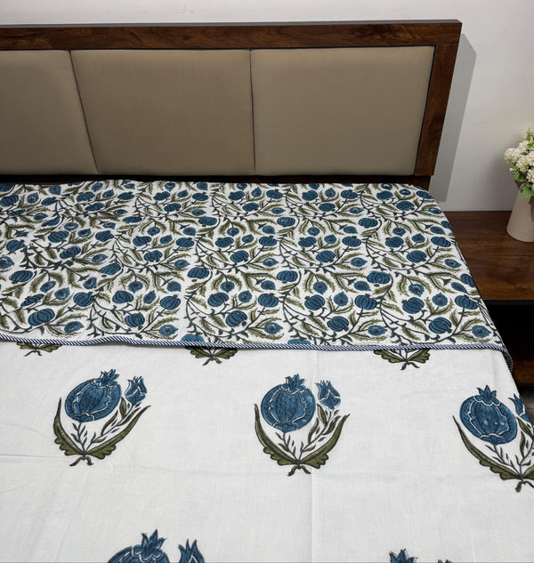 Bed with floral patterned bedspread and wooden headboard
