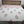 Bed with floral patterned bedspread against a white wall
