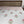 Floral patterned bedspread on a bed with a wooden headboard and nightstand.